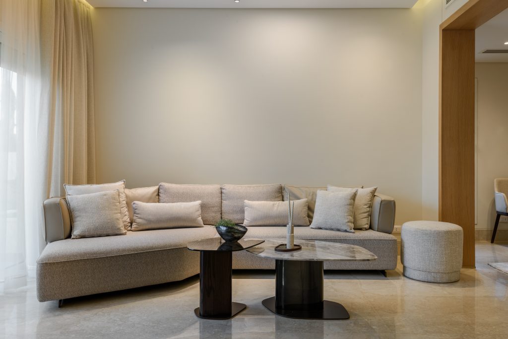 Modern living room in Mivida featuring a contemporary sofa, center table, and neutral palette